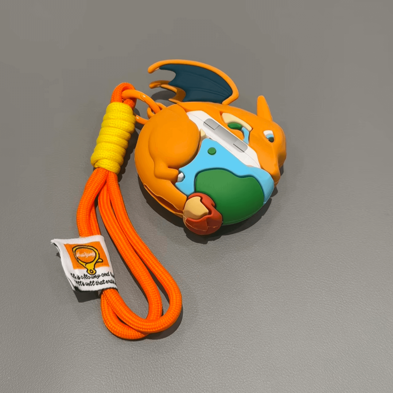 Full view of Charizard AirPods case with orange strap, portable and travel-friendly Pokemon cover