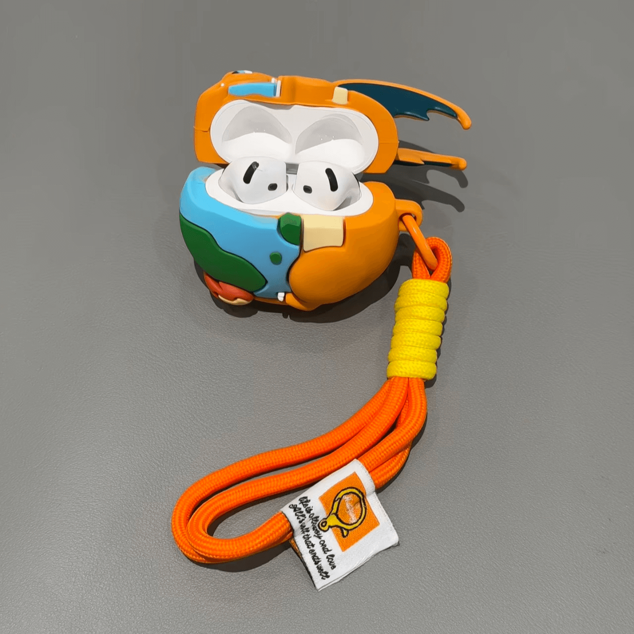 Close-up of Charizard AirPods case with earbuds inside, cartoon Pokemon earphone cover