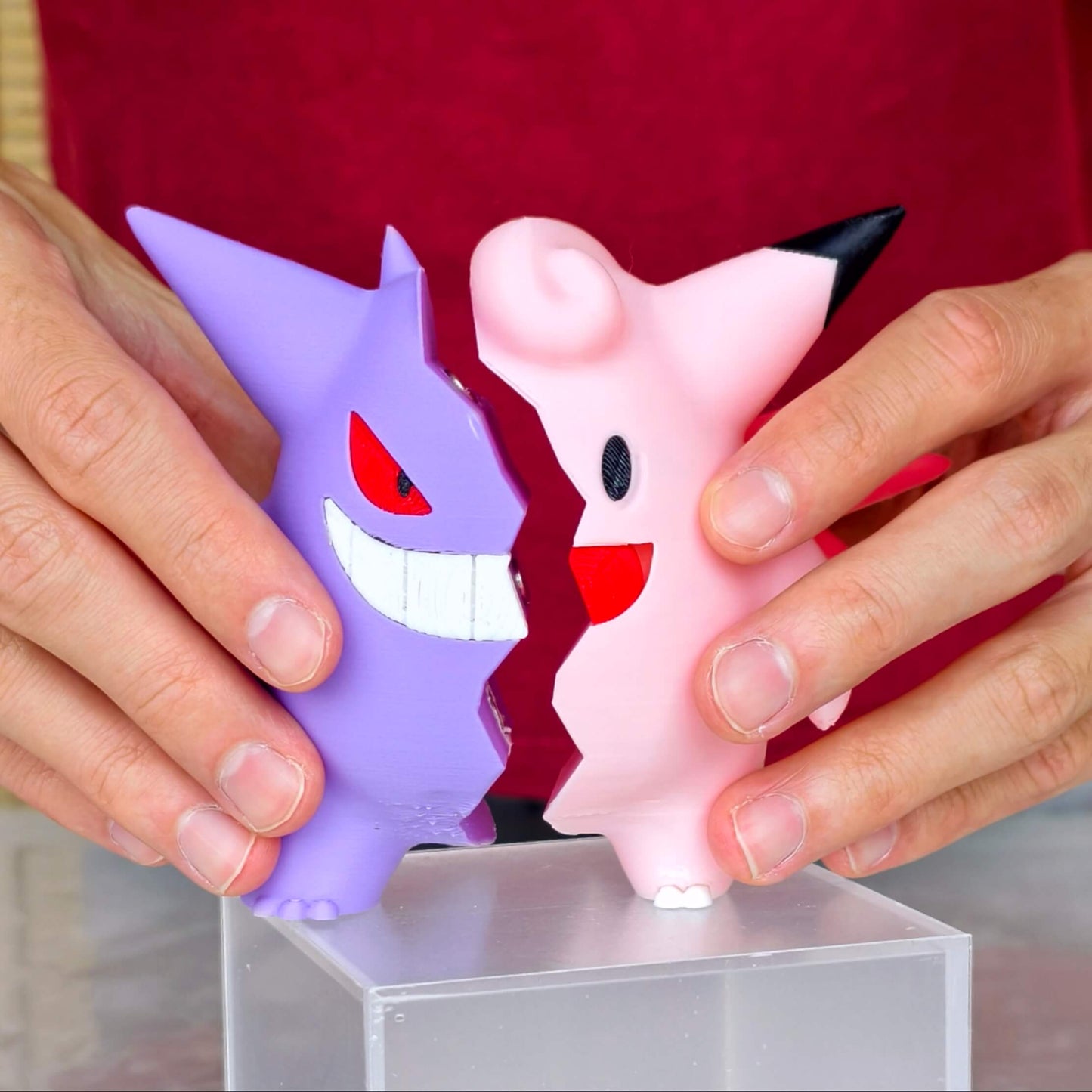 Hands holding Gengar and Clefable half fusion figure, magnetic Pokémon collectible for display