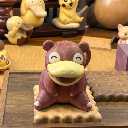 Front view of handcrafted wooden Slowpoke figurine made from red cedar and boxwood, sitting on a biscuit-shaped base
